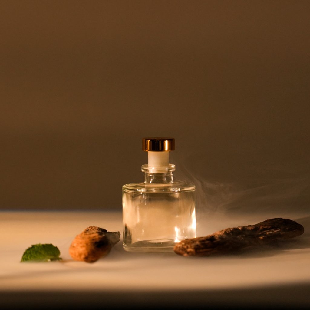 Clear glass aromatherapy bottle in a warm editorial setting