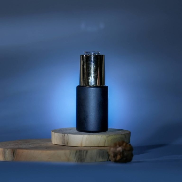 Deep blue thick-wall glass skincare bottle with press dropper