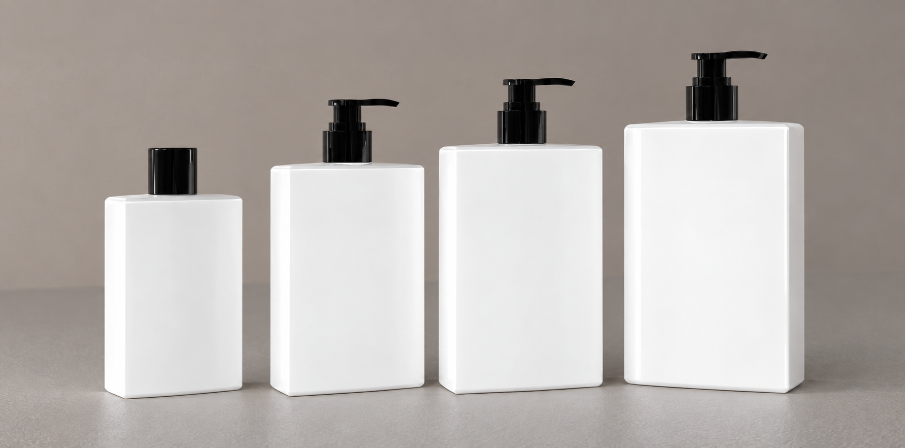 Four white rectangular body care bottles in graduated sizes